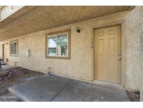 Charming condo exterior featuring a window and doorway with the house number 129 at 2220 W Dora St # 129, Mesa, AZ 85201