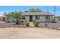 Charming single-story home with desert landscaping, mature palm tree, and quaint red brick walkway leading to the front door at 38234 N 15Th Ave, Phoenix, AZ 85086