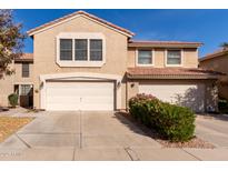 Two-story home featuring a three-car garage, tile roof, and a tidy yard with mature landscaping at 4122 E Jojoba Rd, Phoenix, AZ 85044