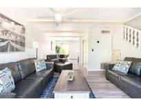 Bright living room featuring leather sofas, ceiling fan, wooden beams and an open floorplan at 4620 N 68Th St # 117, Scottsdale, AZ 85251