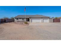 Charming single-story home featuring a three-car garage, desert landscaping, and a flagpole displaying the American flag at 532 N 102Nd Pl, Mesa, AZ 85207