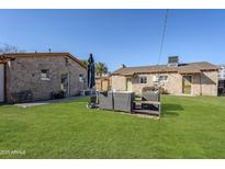Spacious backyard features lush green grass, stone buildings, and comfortable seating at 541 W Edgemont Ave, Phoenix, AZ 85003