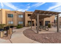Outdoor common area with covered seating, landscaping, and pathways at 8155 E Roosevelt St # 112, Scottsdale, AZ 85257