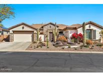 Charming single-story home with desert landscaping and stone accents on a sunny day at 1918 W Medinah Ct, Anthem, AZ 85086