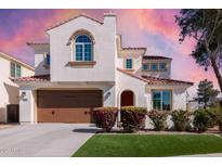 Inviting two-story home featuring a red-tiled roof, beautiful landscaping, and an attached two-car garage at 2300 W Sunrise Pl, Chandler, AZ 85248