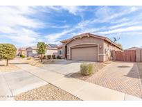 Charming single-story home with well-maintained desert landscaping and a two-car garage on a sunny day at 24027 N 164Th Dr, Surprise, AZ 85387