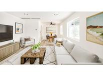 Bright living room with a large sofa, modern decor, and an adjacent dining area bathed in natural light at 3322 E Willetta St, Phoenix, AZ 85008