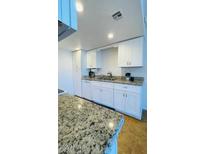 Kitchen showcasing white cabinets, granite counters, and stainless steel sink at 3810 N Maryvale Pkwy # 1068, Phoenix, AZ 85031