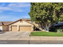 Beautiful home with a two-car garage, complemented by a lush lawn and mature tree at 474 E Baylor Ln, Gilbert, AZ 85296