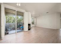 Bright living room featuring a fireplace, wood floors, and balcony access at 9550 E Thunderbird Rd # 259, Scottsdale, AZ 85260