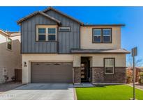 Two story home featuring a two car garage, gray siding, brickwork and manicured lawn against a clear sky at 1075 S Tumbleweed Ln, Chandler, AZ 85286