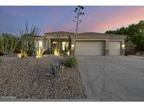 Charming desert home featuring xeriscape landscaping, a three car garage, and a tile roof at 12593 E Desert Cove Ave, Scottsdale, AZ 85259