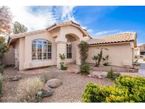 Charming single-story home featuring a tiled roof, arched entry, and desert landscaping under a bright, sunny sky at 1409 W Maria Ln, Tempe, AZ 85284