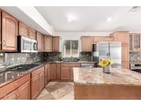Well-equipped kitchen featuring granite counters, a breakfast bar, and stainless steel appliances at 1409 W Maria Ln, Tempe, AZ 85284