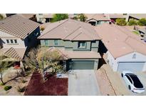 A birds eye view of a two-story home with an attached two car garage, small tree, and nicely landscaped yard at 21868 S 215Th St, Queen Creek, AZ 85142