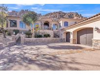 Elegant stucco home with three-car garage, stone accents, desert landscaping, and majestic mountain backdrop at 25572 N 113Th Way, Scottsdale, AZ 85255
