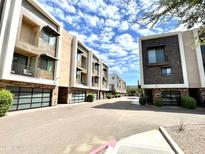 View down private street of modern condo exteriors with attached garages, sidewalks, and landscaping at 3233 N 70Th St # 1006, Scottsdale, AZ 85251