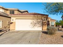 Beige single-Gathering home displaying a two car garage, desert landscaping and concrete driveway at 45 S 238Th Dr, Buckeye, AZ 85396