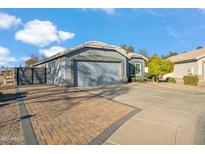 Charming single-story home showcasing a gray facade, desert landscaping, and a two-car garage at 644 W Dublin St, Gilbert, AZ 85233