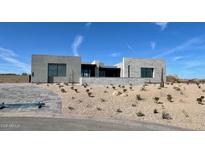 Modern desert home with clean lines, neutral colors, and drought-resistant landscaping under a bright blue sky at 13116 E Desert Holly Dr, Scottsdale, AZ 85255