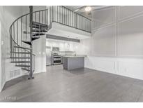 Bright living room featuring a spiral staircase, open floor plan, and modern gray-scale finishes at 1351 N Pleasant Dr # 2030, Chandler, AZ 85225