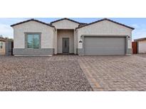 Charming stucco home with a two-car garage and patterned brick driveway at 14240 S Overfield Rd, Arizona City, AZ 85123