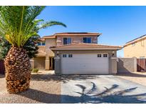 Two story home with a two car garage, desert landscaping and tiled roof under a clear blue sky at 14970 N 172Nd Dr, Surprise, AZ 85388