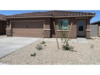 Charming single-story home featuring a tile roof, two-car garage, and low-maintenance desert landscaping at 24619 W St Catherine Ave, Buckeye, AZ 85326