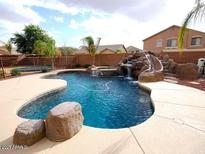 Amazing backyard pool area with rock features and water slide, perfect for Gathering fun! at 4253 E Colonial Dr, Chandler, AZ 85249