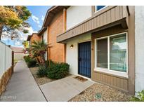 Charming townhome featuring a blue security door and well-maintained landscaping with gravel and a tidy walkway at 5106 N 17Th Ave # 11, Phoenix, AZ 85015