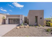 Stunning contemporary home featuring desert landscaping, a sleek garage door, and a stylish entrance at 14445 N Valencia Dr, Fountain Hills, AZ 85268