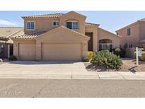 Warm, tan two-story home featuring a tile roof, a three-car garage, and desert landscaping at 15825 S 1St Ave, Phoenix, AZ 85045