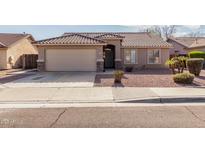 Charming single-story home with a well-manicured lawn and a neutral-toned exterior at 16043 W Saguaro Ln, Surprise, AZ 85374