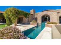 Gorgeous stone home featuring outdoor patio with a sparkling pool and lush climbing plants at 9290 E Thompson Peak Pkwy # 470, Scottsdale, AZ 85255