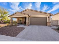 Charming single-story home featuring a two-car garage and desert landscaping at 13568 N 144Th Dr, Surprise, AZ 85379