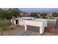 Beautiful modern home with a gray garage door, desert landscaping, and mountain views at 14025 N 11Th Pl, Phoenix, AZ 85022