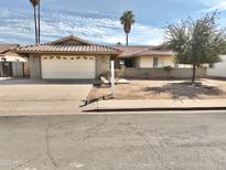 Charming single-story home with a well-maintained front yard and a two-car garage at 1455 W Posada Ave, Mesa, AZ 85202