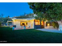 Beautiful backyard featuring a brick patio, lush green lawn and mature shade tree, perfect for outdoor living and entertaining at 2260 E Palmaire Ave, Phoenix, AZ 85020
