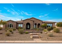 Beautiful brick home with a tile roof and meticulously maintained desert landscaping in front at 10902 N 138Th Pl, Scottsdale, AZ 85259