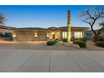 Inviting desert home with stone accents, three-car garage, and lush, low-maintenance landscaping at 10999 E Acoma Dr, Scottsdale, AZ 85255
