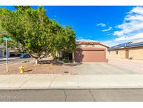 Charming single-story home featuring a two-car garage and mature shade tree at 11032 W Frier Dr, Glendale, AZ 85307
