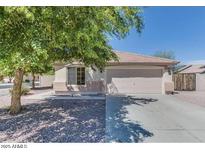 Charming single-story home with a well-maintained front yard and a two car garage at 14930 N Gil Balcome Ct, Surprise, AZ 85379