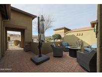 Relaxing patio space with a brick floor and a large umbrella for shade at 17662 W Cedarwood Ln, Goodyear, AZ 85338