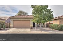 Charming single-story home featuring desert landscaping, a two-car garage, and a cozy front porch at 1829 E Sandalwood E Rd, Casa Grande, AZ 85122