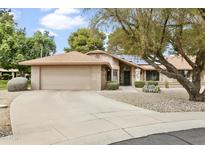 Charming single-story home featuring a well-maintained yard, two car garage and desert landscaping in front at 20215 N Medallion Ct, Sun City West, AZ 85375