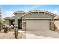Charming single-story home with a well-maintained front yard and a two-car garage at 30428 N Saddlebag Ln, San Tan Valley, AZ 85143