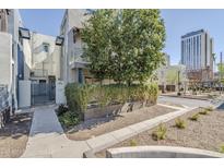 Inviting condo exterior with well-maintained landscaping, mature tree, and easy access to a nearby city street at 615 E Portland St # 160, Phoenix, AZ 85004
