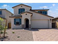 Charming two-story home featuring desert landscaping, an arched entryway, and a two-car garage at 12219 W Caraveo Pl, Peoria, AZ 85383