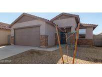 Charming single-story home featuring a two-car garage, low maintenance landscaping and neutral color palette at 17057 W Seldon Ln, Waddell, AZ 85355