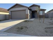 Charming single-story home with low-maintenance desert landscaping and a two-car garage at 17057 W Seldon Ln, Waddell, AZ 85355